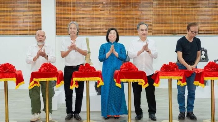Các nghệ sĩ cắt băng khai mạc triển lãm.
