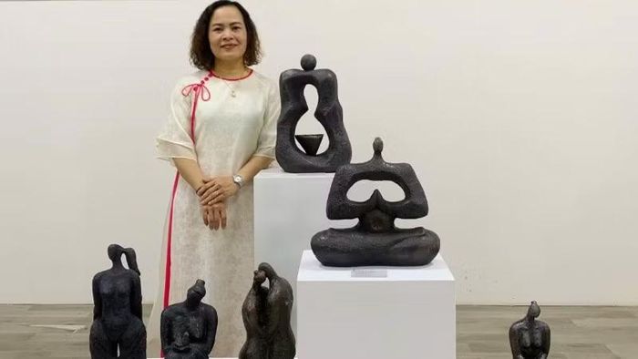 Họa sĩ Nguyễn Thị Thu Trang bên các tác phẩm trưng bày tại triển lãm.