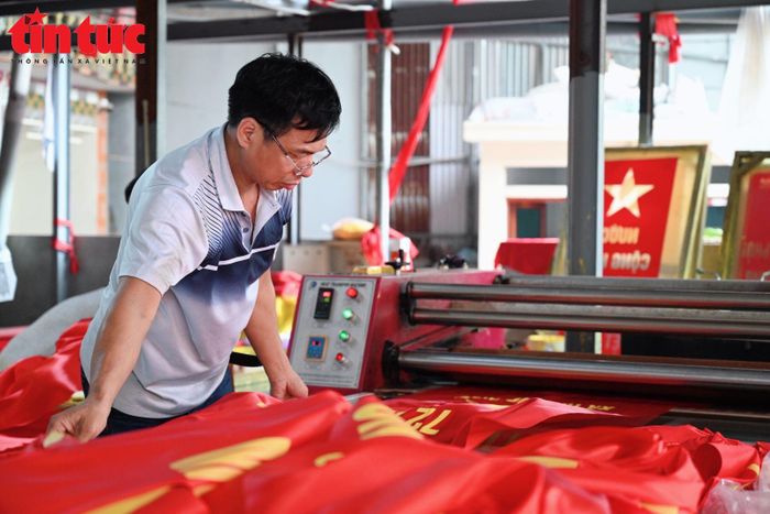 Anh Nguyễn Văn Phục cẩn thận kiểm tra từng lá cờ, khâu cuối trước khi sản phẩm rời xưởng.