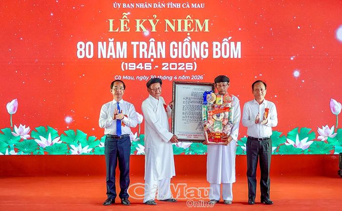  Đồng chí Phạm Văn Thiều, Phó Bí thư Tỉnh ủy, Chủ tịch HĐND tỉnh (bìa phải) và đồng chí Hồ Thanh Thủy, Phó Bí thư Tỉnh ủy, Chủ tịch Ủy ban MTTQ Việt Nam tỉnh Cà Mau, trao tư liệu bức thư của Chủ tịch Hồ Chí Minh gửi cụ Cao Triều Phát đến đại diện Ban Quản lý di tích Địa điểm trận Giồng Bốm.