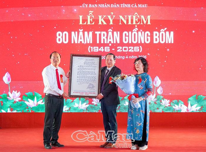 Đồng chí Nguyễn Hồ Hải, Ủy viên Ban Chấp hành Trung ương Đảng, Bí thư Tỉnh ủy (bìa trái), trao tư liệu bức thư của Chủ tịch Hồ Chí Minh gửi cụ Cao Triều Phát đến đại diện gia đình.