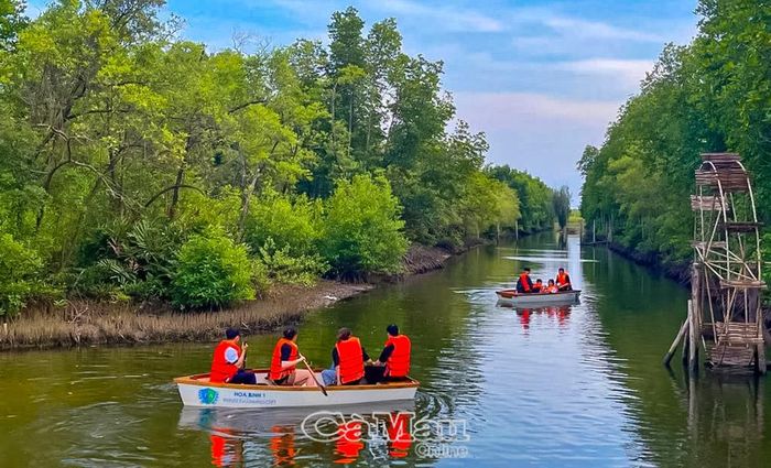 Du khách bơi xuồng xuyên rừng, tại Khu du lịch Điện gió Hoà Bình 1 (xã Vĩnh Hậu).