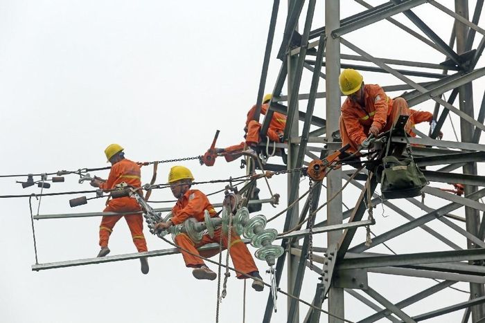 Công nhân Công ty Lưới điện cao thế miền Bắc xử lý sự cố tại cột 110 Kv. Ảnh: Huy Hùng – TTXVN