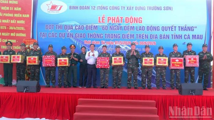 Phó Bí thư Thường trực Tỉnh ủy Cà Mau Huỳnh Quốc Việt (áo trắng) và Phó Chủ tịch Ủy ban nhân dân tỉnh Lê Văn Sử (đứng kế) tặng quà động viên các đơn vị thi công thuộc Binh đoàn 12.