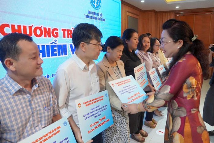  Lãnh đạo BHXH TPHCM trao kinh phí cấp BHYT cho người dân đến đại diện các BHXH cơ sở trực thuộc (ẢNH: ĐÔNG SƠN) 