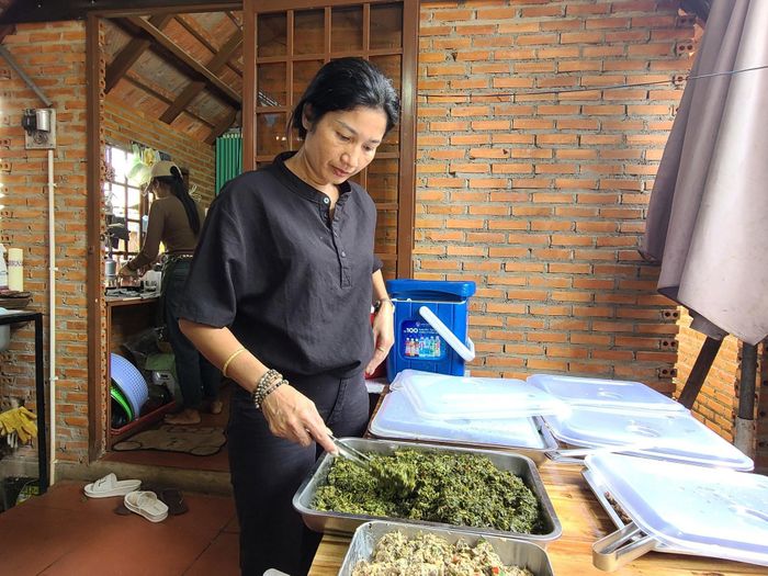 Chị H’Minh Byă, chủ quán Nhà sàn M’Nga Tăng Bi chuẩn bị món ăn truyền thống phục vụ khách du lịch