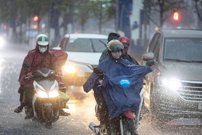 Người dân TP.HCM di chuyển dưới cơn mưa lớn chiều 2/5. Ảnh: Khương Nguyễn.