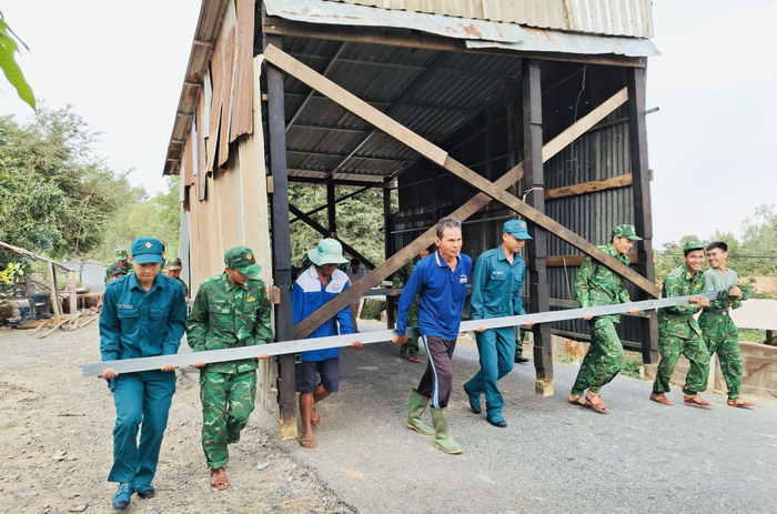 Cán bộ, chiến sĩ Đồn Biên phòng Sông Trăng giúp nhân dân trên địa bàn xã Hưng Điền di dời nhà cửa.