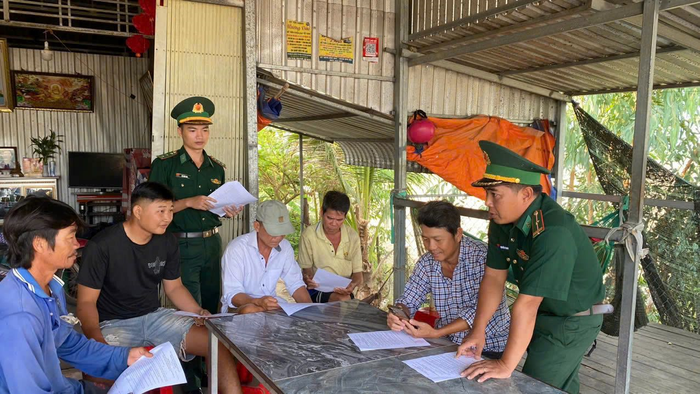 Cán bộ, chiến sĩ Đồn Biên phòng Sông Trăng vận động các hộ dân ký cam kết không tiếp tay cho buôn lậu.