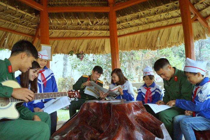 Bộ đội cùng cô giáo và học sinh đọc sách, báo, tạp chí tại một đơn vị Quân đội. Ảnh: Nguyễn Minh