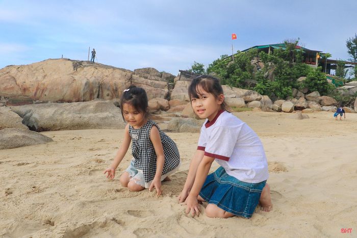 Nhiều em bé thích thú vui chơi trên bãi cát mịn.