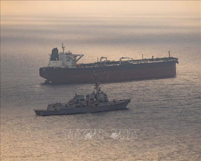 Tàu khu trục USS Rafael Peralta (DDG 115) tiếp cận một tàu hàng đang trong hành trình vào cảng của Iran, trong bối cảnh Mỹ mở rộng phong tỏa các tàu thuyền tại eo biển Hormuz, vịnh Oman ra vùng biển quốc tế, ngày 24/4/2026. Ảnh: REUTERS/TTXVN