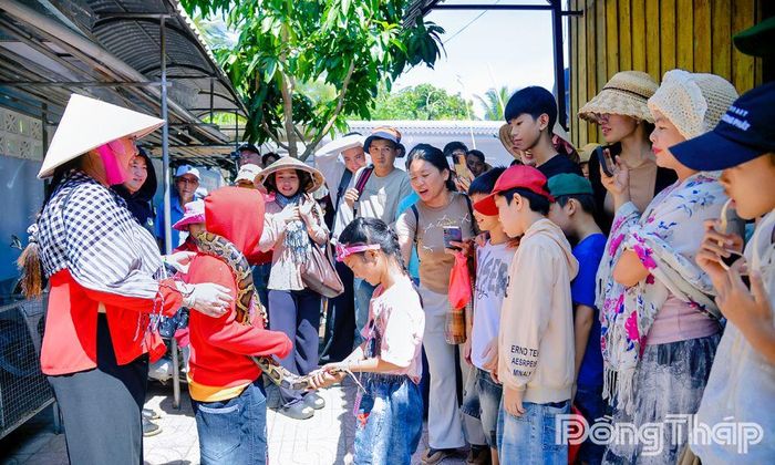 Du khách chụp ảnh cùng trăn tại cù lao Thới Sơn.