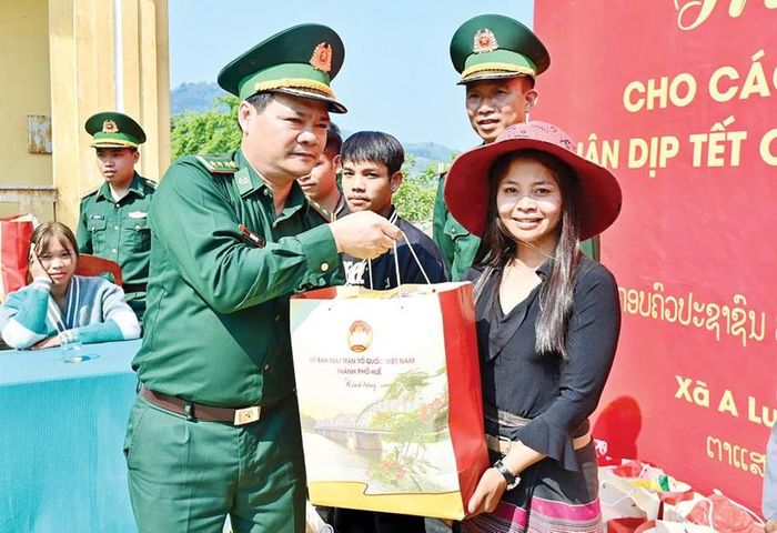 Thượng tá Hồ Văn Việt, Chủ nhiệm Chính trị BĐBP thành phố (trái)trao quà cho người dân Sê Sáp