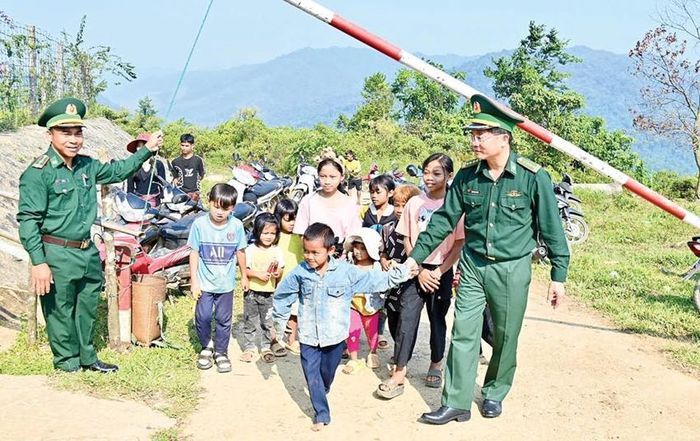 Đại tá Đặng Ngọc Hiệu, Chính ủy BĐBP thành phố (phải) vui cùng trẻ em bản Sê Sáp, Lào