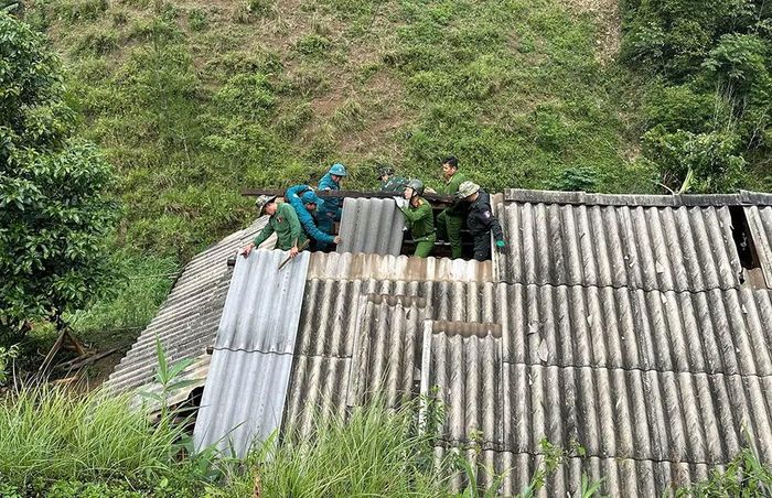 Các CBCS Công an xã Phiêng Khoài hỗ trợ Nhân dân sửa mái nhà.