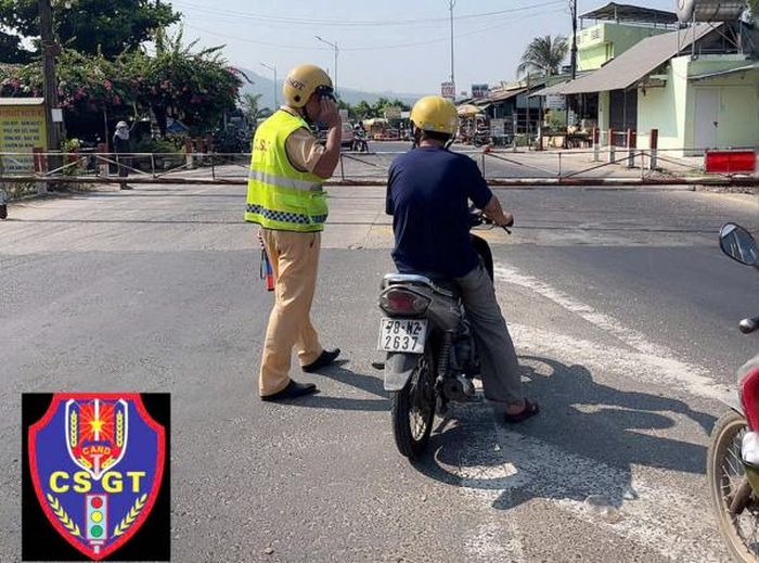 Cán bộ Trạm CSGT Tuy An thuộc Phòng CSGT Công an tỉnh Đắk Lắk nhắc nhở người dân chấp hành pháp luật giao thông đường sắt khi dừng xe trước chắn gác. Ảnh: CSGT ĐL.