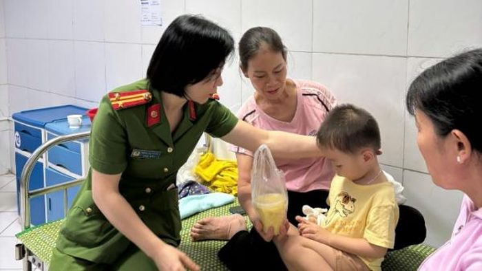 Phụ nữ Công an xã Ái Quốc trao tặng từng suất cháo đến những bệnh nhi và người thân.