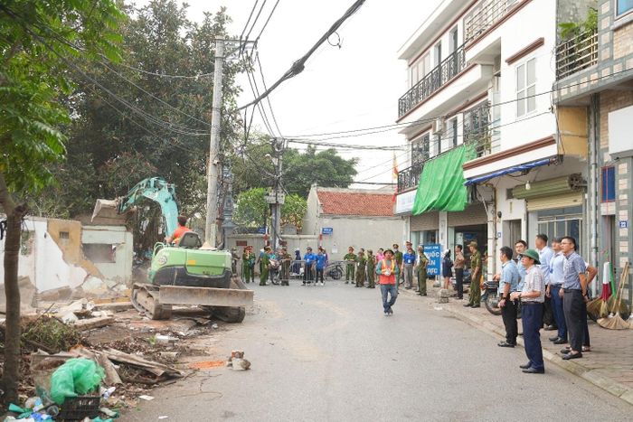 Lực lượng chức năng tổ chức cưỡng chế, tháo dỡ các ki-ốt vi phạm tại khu vực ao Đình thôn Dương Đá. Ảnh: PV