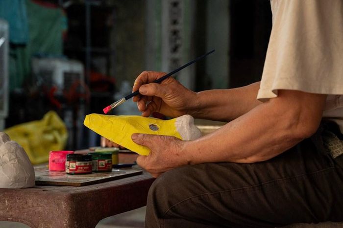 Từng nét vẽ dứt khoát và giàu kinh nghiệm dần hiện lên, không chỉ hoàn thiện hình hài mà còn khắc họa thần thái riêng cho mỗi chiếc mặt nạ