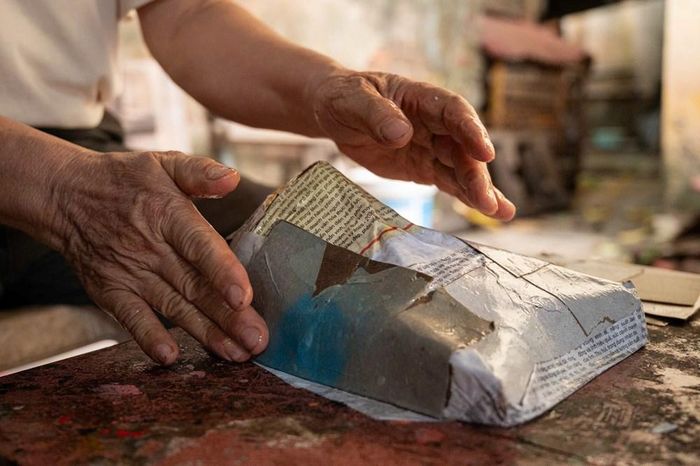 Quy trình bồi giấy là sự kết hợp giữa kĩ thuật và kinh nghiệm được tích lũy qua nhiều năm. Người thợ phải tính toán từng lớp một cách chính xác: lớp giấy khô lót dưới giúp tách khuôn dễ dàng, lớp carton dày tạo nên độ cứng và form dáng, cuối cùng là lớp giấy trắng mịn làm nền cho công đoạn vẽ