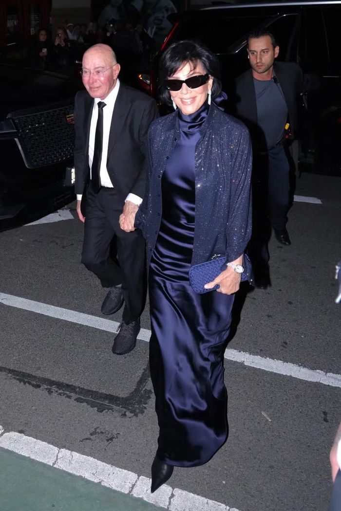 Trong khi đó, mẹ Kendall, bà Kris Jenner, hoàn toàn "kín cổng cao tường" với váy satin cổ lọ màu tím than, kết hợp áo khoác dài tay lấp lánh và boot mũi nhọn. Sánh đôi cùng người đứng đầu gia tộc Kardashian-Jenner là nhà sản xuất phim David Geffen. Ảnh: BackGrid