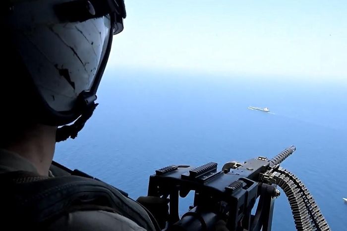 Binh sĩ Mỹ ngồi trên trực thăng theo dõi một tàu chở hàng gần eo biển Hormuz. Ảnh: CENTCOM