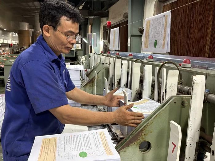 Sách giáo khoa đang được đóng quyển tại nhà máy. (Ảnh: Phạm Mai/Vietnam+)