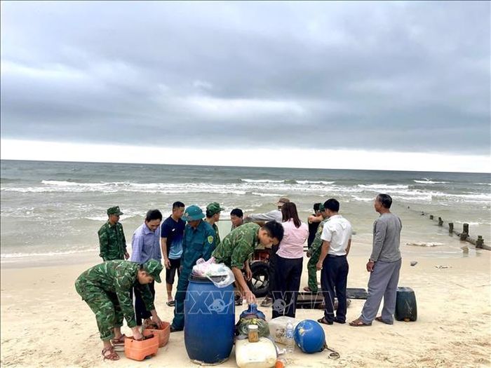 Cán bộ, chiến sĩ Đồn Biên phòng Hải An phối hợp với chính quyền địa phương và người dân hỗ trợ gia đình thu gom tài sản bị trôi dạt. Ảnh: TTXVN phát