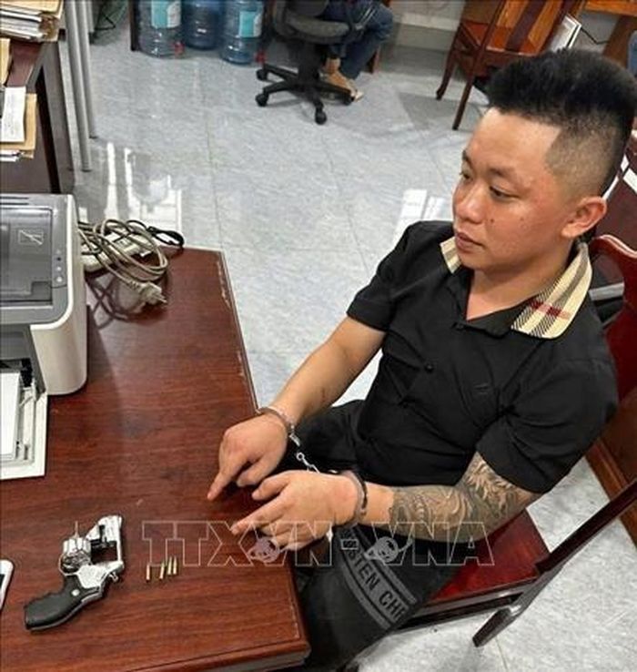 Một trong 2 đối tượng bị bắt quả tang mang súng đi uống cà phê. Ảnh: TTXVN phát