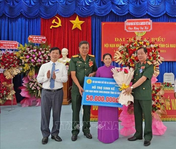 Trung tướng Nguyễn Hữu Chính, Chủ tịch Hội Nạn nhân chất độc da cam/Dioxin Việt Nam, trao bảng tượng trưng hỗ trợ sinh kế cho nạn nhân chất độc da cam tỉnh Cà Mau.