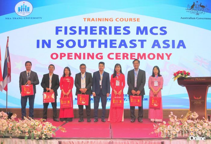 Đại diện Trường Đại học Nha Trang tặng hoa cho giảng viên và khách mời tham dự khai mạc khóa tập huấn.