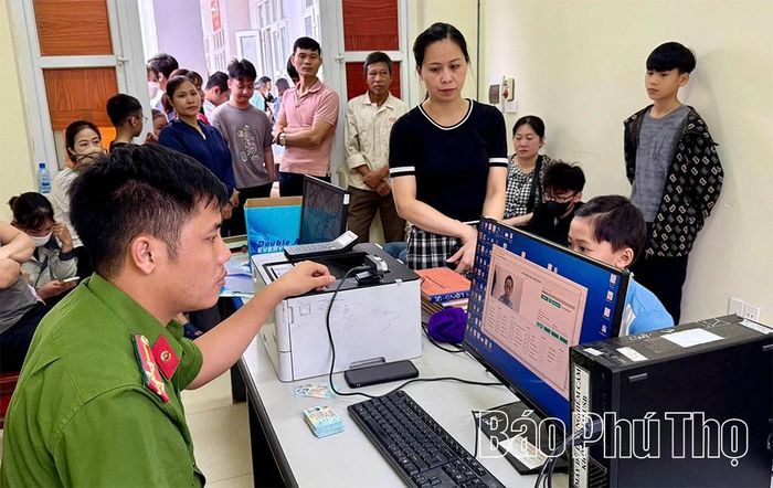Các em học sinh được cán bộ hỗ trợ lấy mống mắt thực hiện định danh mức độ 2.