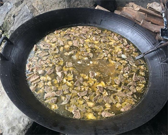 Người dân nấu thắng cố ngựa bằng bếp củi tại chợ phiên Si Ma Cai, phục vụ thực khách trong phiên chợ cuối tuần