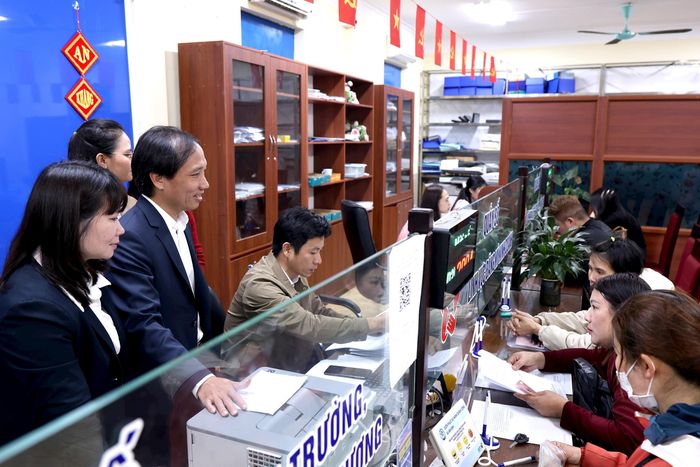 Lãnh đạo UBND xã Vân Đình kiểm tra, theo dõi công tác tiếp nhận và giải quyết thủ tục hành chính. Ảnh: Lại Tấn