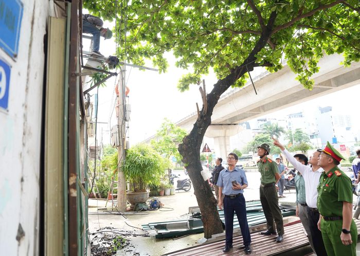 Lực lượng chức năng giám sát công tác giải phóng mặt bằng. Ảnh: Hữu Tiệp