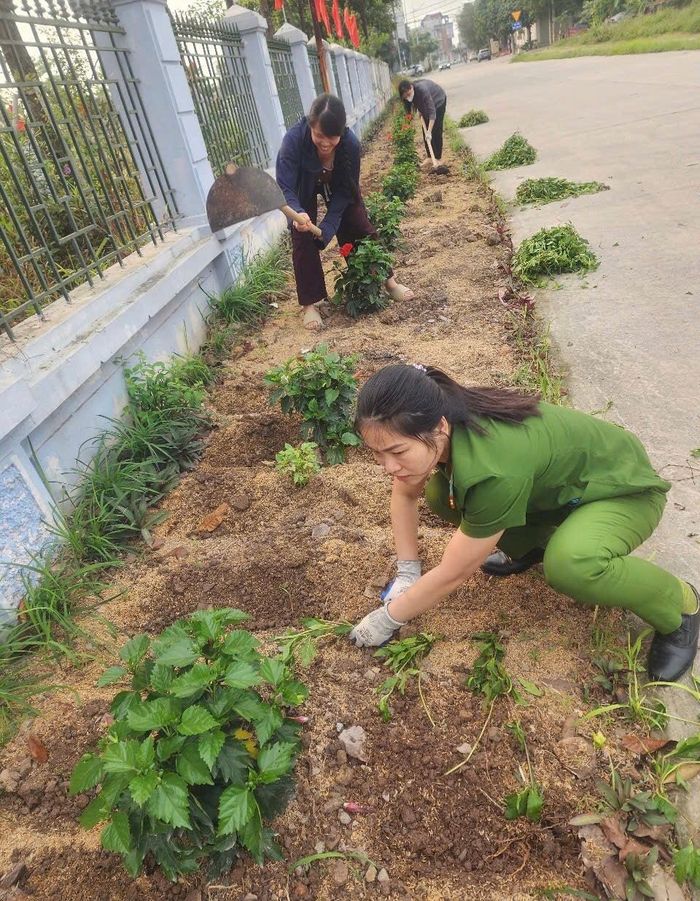 Các hội viên phụ nữ xã Mỹ Đức phối hợp với Chi hội phụ nữ Công an xã trồng hoa tại các tuyến đường. Ảnh: VB