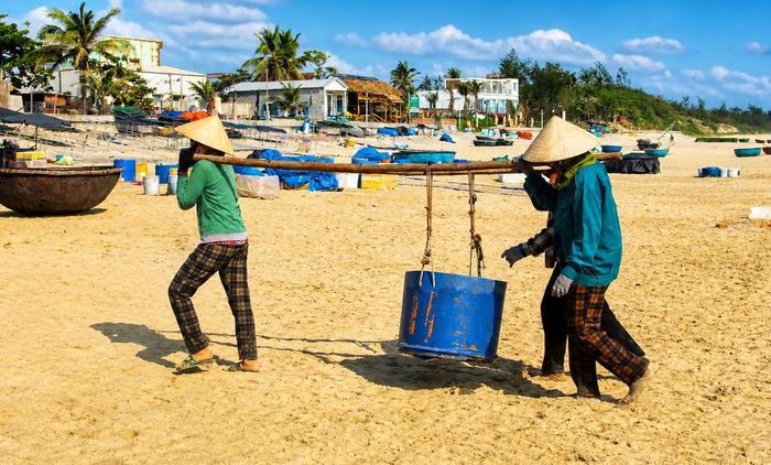 Những người phụ nữ vận chuyển hải sản lên bờ. Ảnh: CĐ.