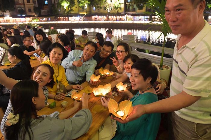 Du khách thích thú khi đã tự tay hoàn thiện những chiếc đèn hoa đăng và thắp lên những ngọn nến lung linh.