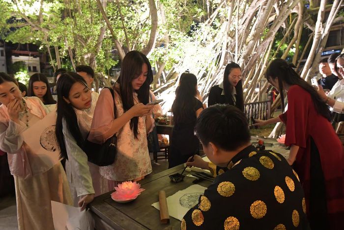 Hoạt động viết thư pháp thu hút nhiều du khách tham gia, mỗi nét chữ không chỉ thể hiện sự trân trọng tri thức mà còn gửi gắm ước vọng cá nhân trong không gian giàu tính biểu tượng.