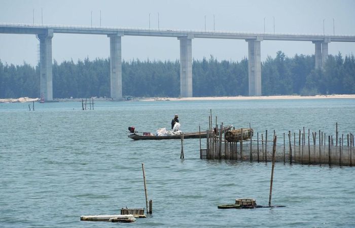 Khung cảnh yên bình, hoang sơ ở phá Tam Giang cùng cầu vượt cửa biển Thuận An hiện đại ở thành phố Huế. Ảnh: Nguyên Lý - TTXVN