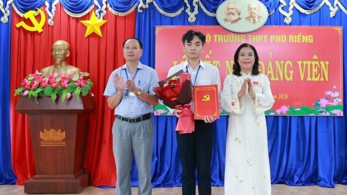 Em Bùi Anh Tú (lớp 12A1), Trường trung học phổ thông Phú Riềng nhận Quyết định kết nạp đảng viên của Đảng ủy xã Phú Riềng.