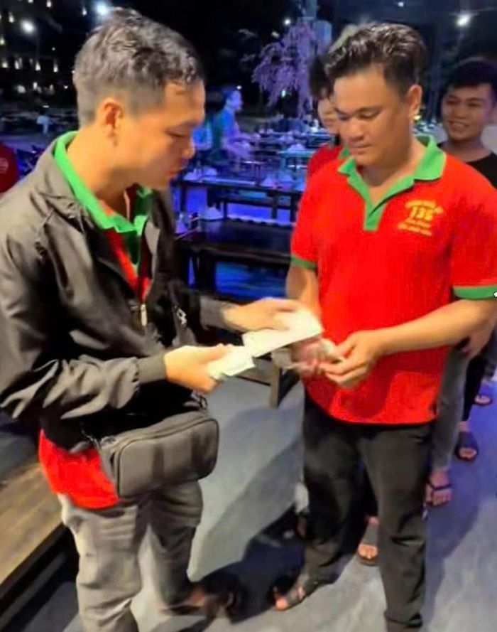 Anh Phát tặng tiền cho nhiều người sau khi trúng độc đắc 18 tỉ đồng. Ảnh cắt ra từ clip