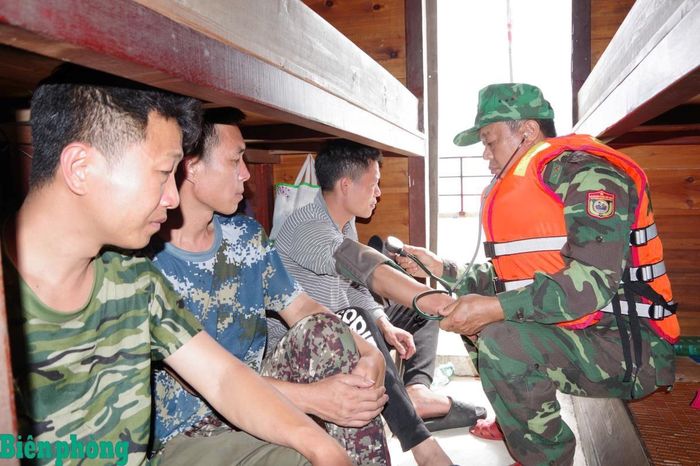 Cán bộ quân y Đồn Biên phòng Bạch Long Vĩ hỗ trợ chăm sóc y tế cho các thuyền viên gặp nạn. Ảnh: Xuân Chính