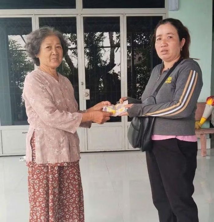 Bà Sia (trái) trả lại vé số trúng thưởng và tiền cho chị Vẹn.