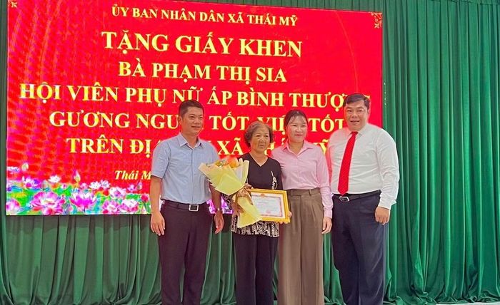 Lãnh đạo UBND xã Thái Mỹ tặng giấy khen cho bà Phạm Thị Sia.