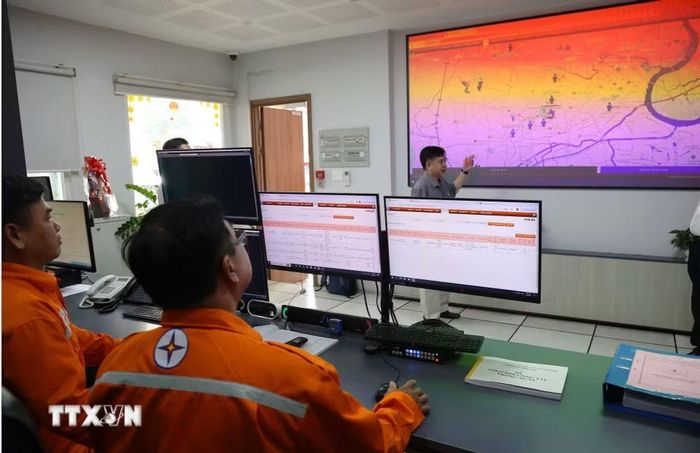 Nhân viên ngành điện ứng dụng công nghệ quản lý địa bàn và người lao động trong quá trình cung cấp điện. (Ảnh: Thanh Vũ/TTXVN)