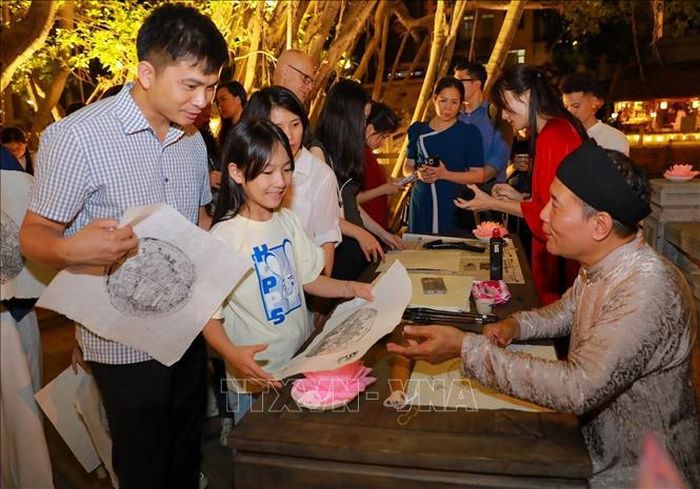 Người dân và du khách trải nghiệm in tranh và xin chữ.