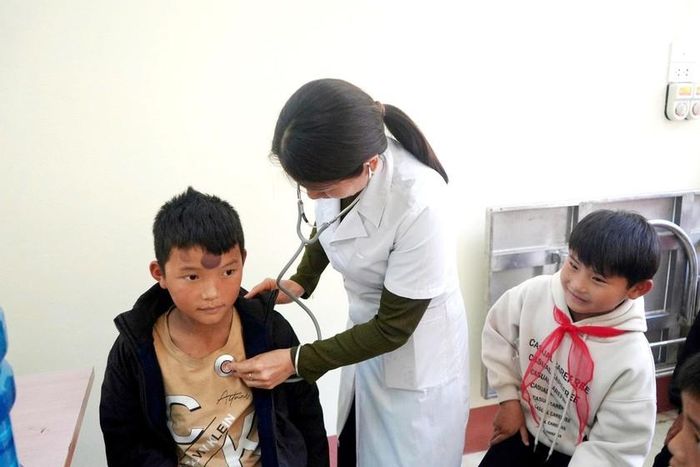 Nhân viên y tế khám sàng lọc trước khi cho học sinh uống thuốc Vermox 500mg tẩy ký sinh trùng đường ruột. Ảnh: TL