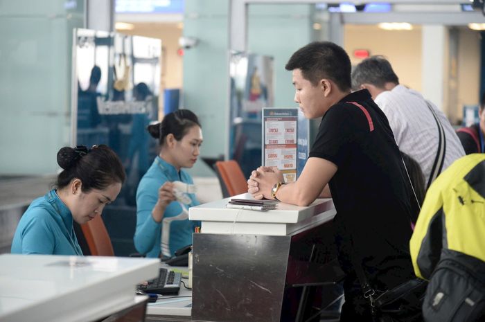 Nhân viên hàng không hỗ trợ hành khách làm thủ tục. Ảnh: Quang Thái